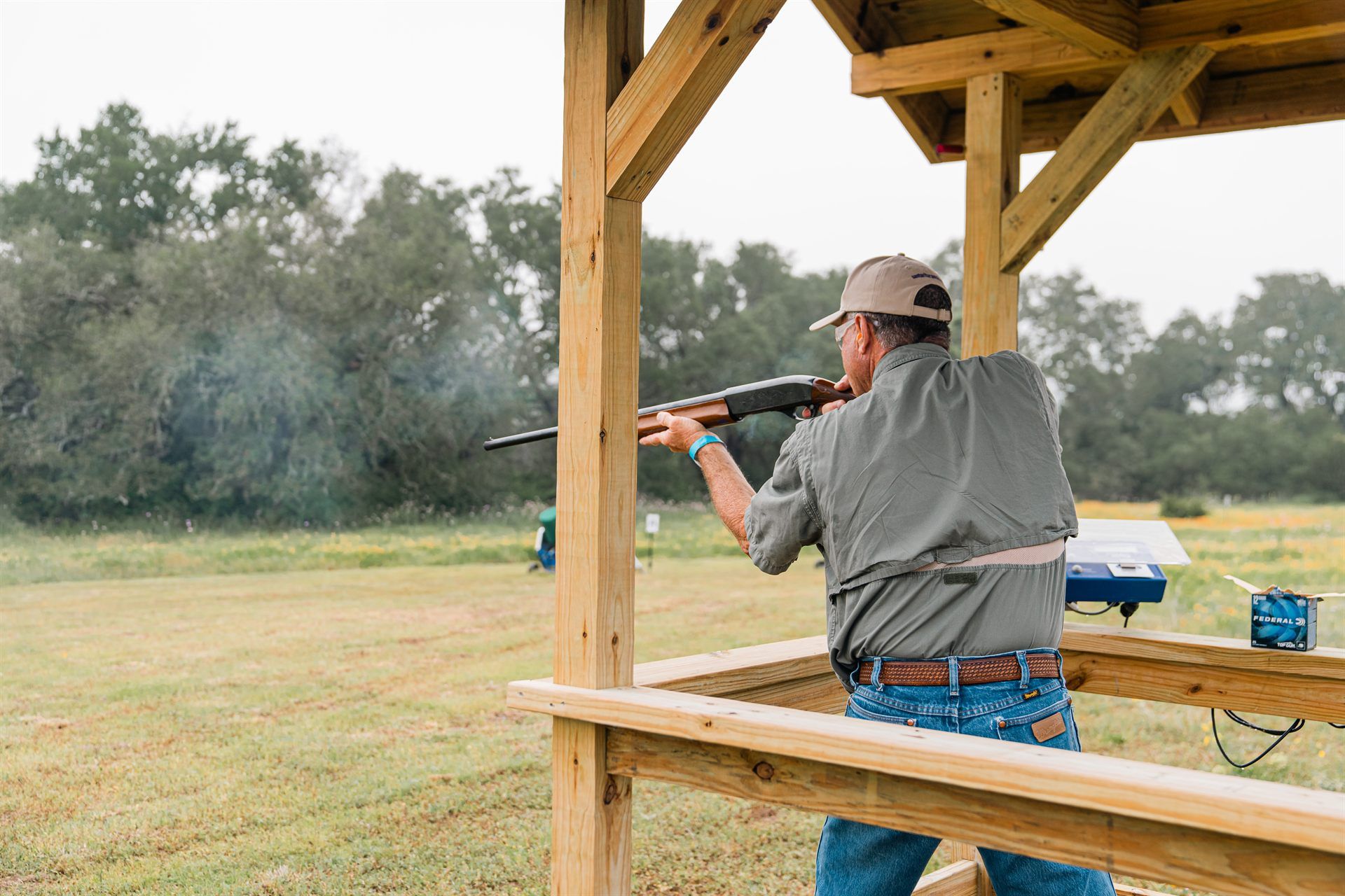 A shooter tracking a clay from a covered stand on the Skyline sporting clays course at Staccato Ranch Texas.